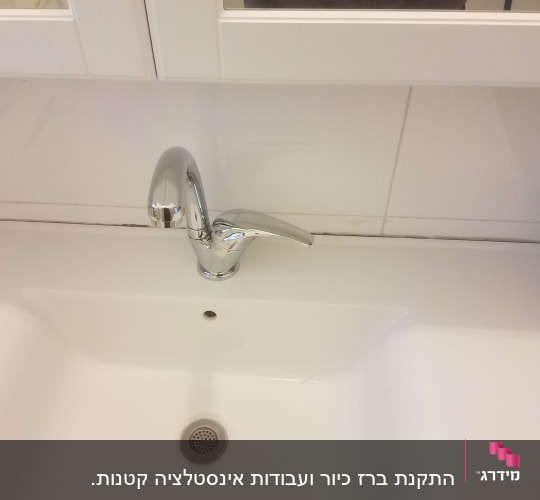 ברז כרום מעל כיור לבן בחדר אמבטיה